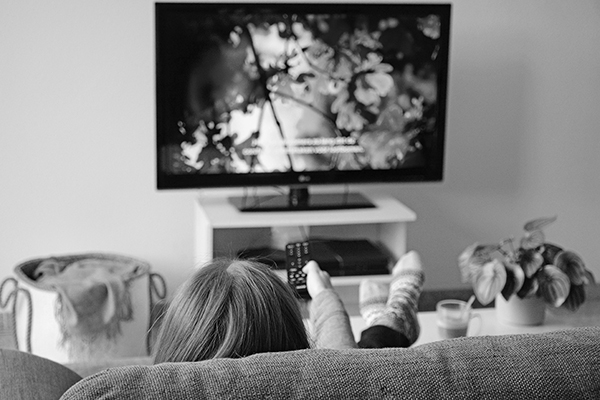 Jeune femme regardant un film avec sous-titres sur télévision