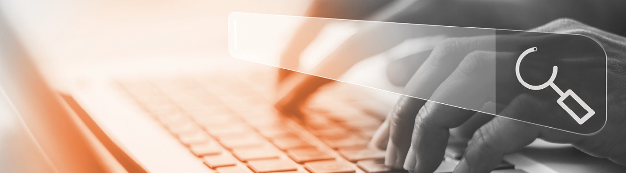 Worker typing on a keyboard with a search box in the foreground