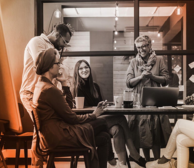 People sitting around a table collaborating on a creative project. 