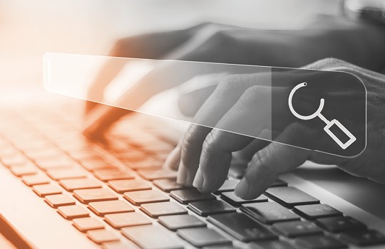 Worker typing on a keyboard with a search box in the foreground