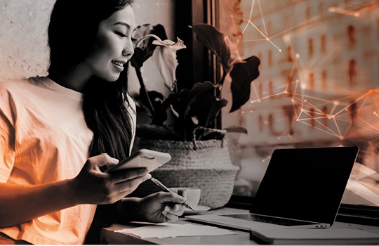 Woman working on laptop and mobile phone