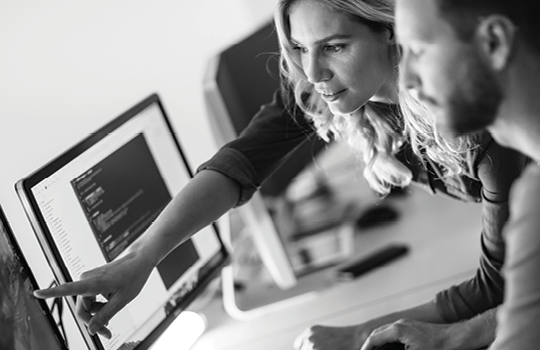 Two people collaborating on a computer over a project