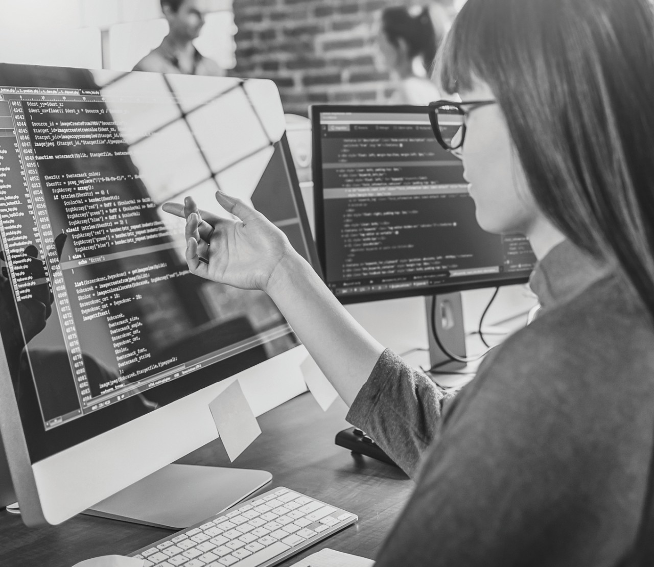 Person pointing to a line of software code on the computer