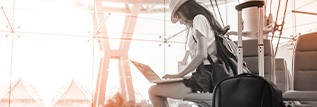 Traveller sitting in airport using laptop