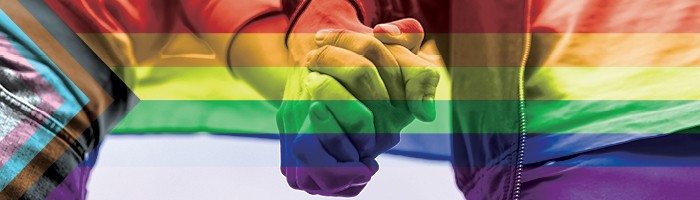 Deux personnes se tenant la main avec un drapeau du mois de la Pride