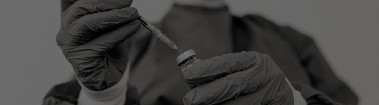 A medical provider fills a syringe.